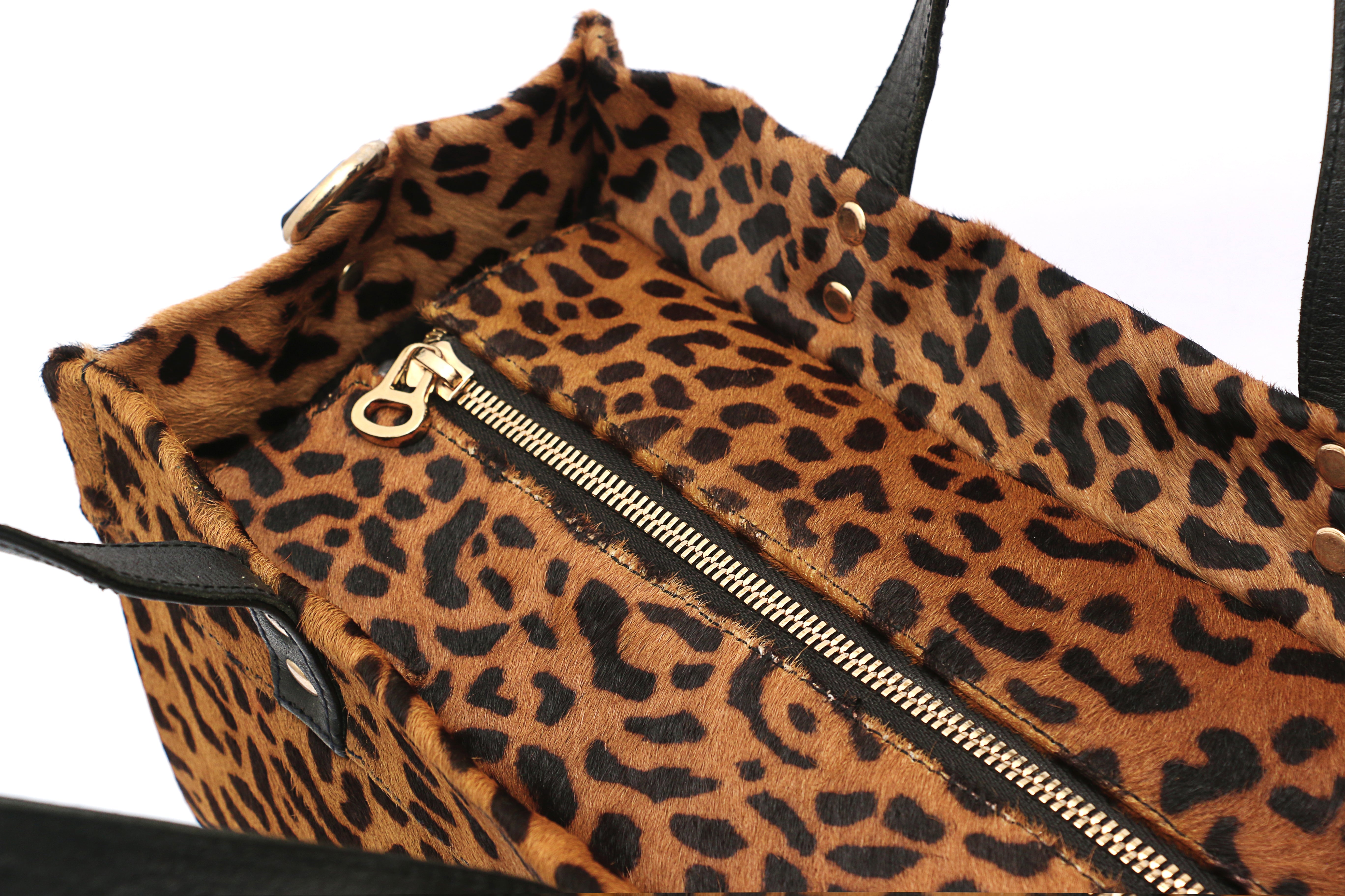 Detail view Leopard print bag with a gold zipper on a white background