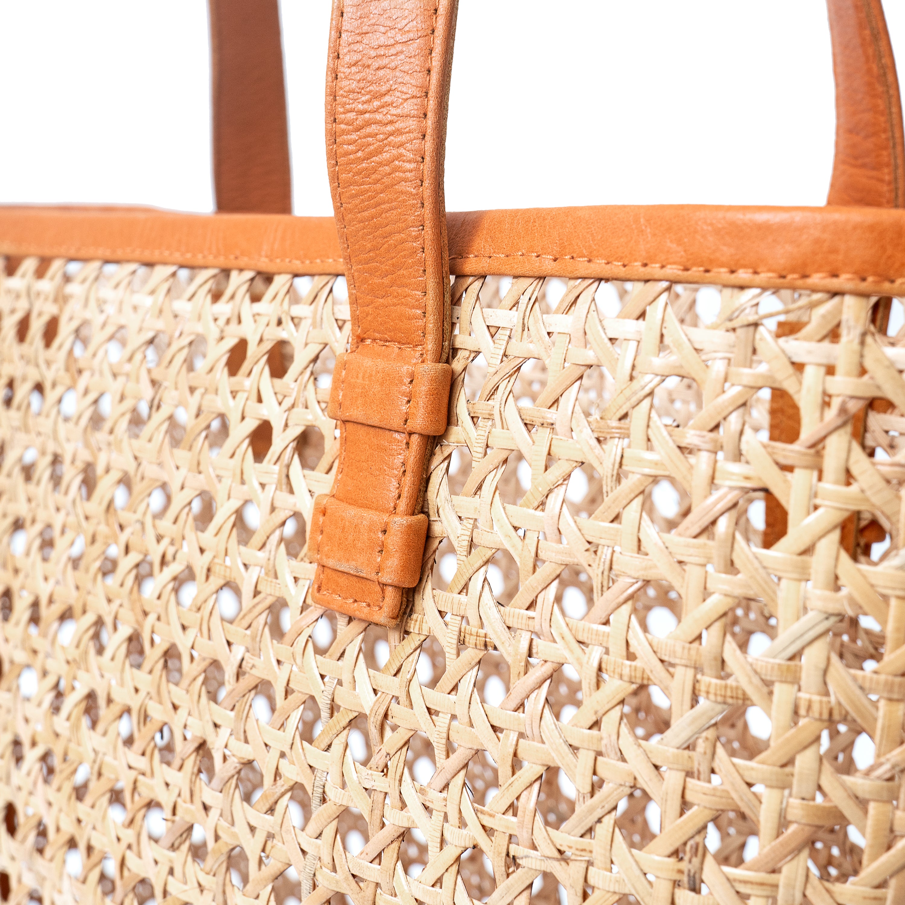 Close up view open weave rattan cane webbing and leather tote shoulder bag