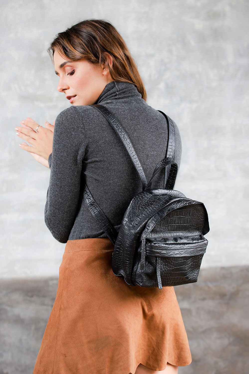Model wearing black leather mini backpack