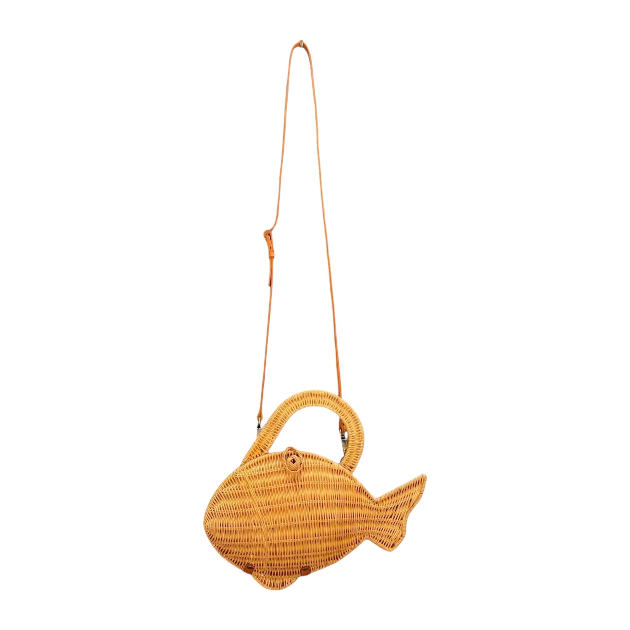 A woven fish-shaped shoulder bag in natural tan rattan with a thin genuine leather crossbody shoulder strap and a top handle.