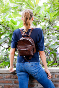 Model wearing brown croco embossed small leather backpack