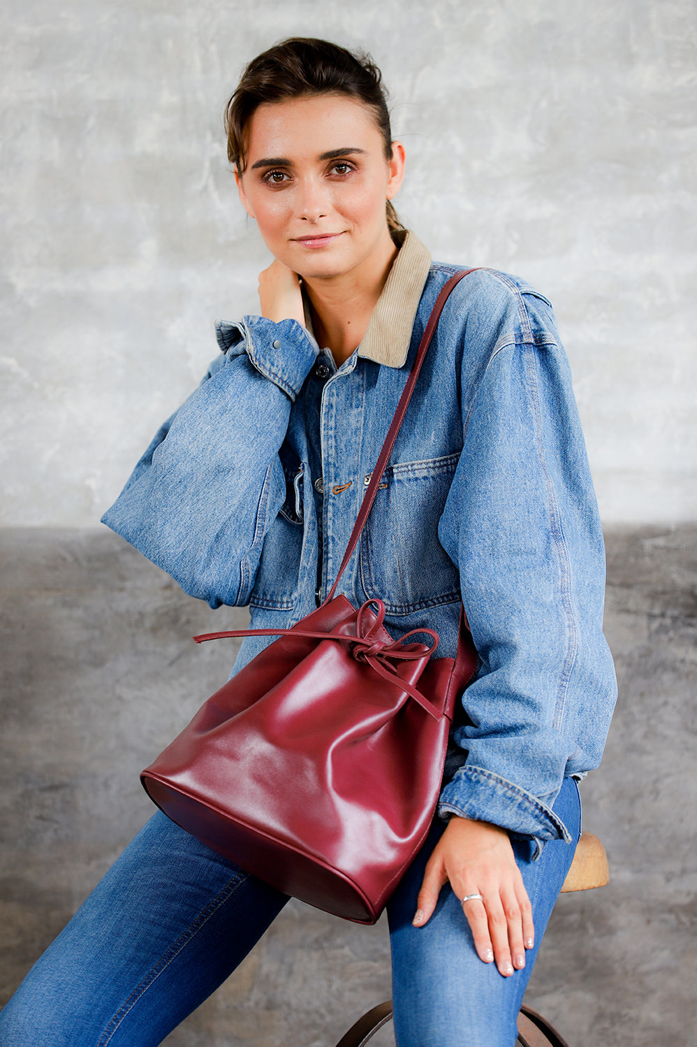 model wearing genuine leather crossbody bucket shoulder handbag