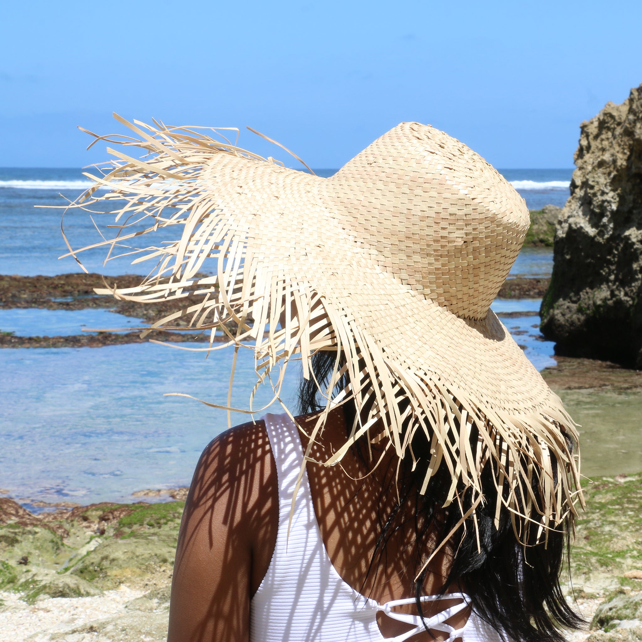 Model wearing natural color wide brim frayed edge beach straw raffia sun women hat
