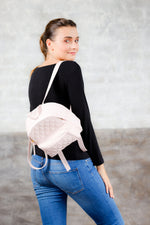 Model wearing light pink quilted leather small backpack