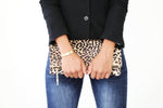 Model front view holding cream spotted leopard foldover clutch handbag