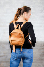 Model wearing tan genuine leather mini backpack